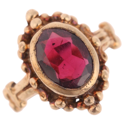 1340 - A 9ct gold single stone garnet dress ring, rub-over set with oval mixed-cut garnet, indistinct hallm... 