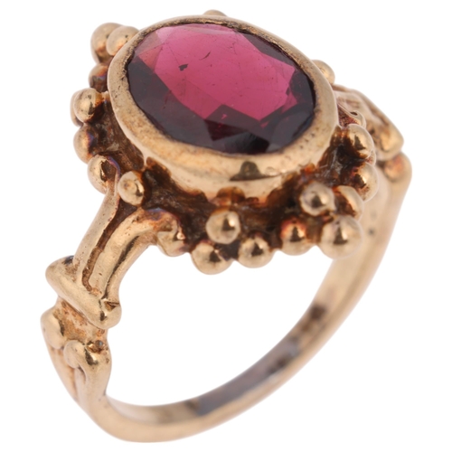 1340 - A 9ct gold single stone garnet dress ring, rub-over set with oval mixed-cut garnet, indistinct hallm... 