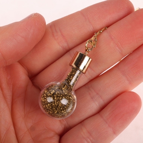 1363 - A novelty gold shavings pendant necklace, the glass tube filled with gold shavings with gold plated ... 