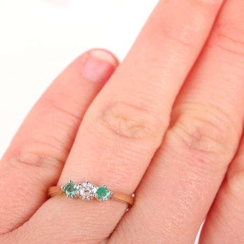 1365 - A 9ct gold three stone emerald and diamond ring, setting height 4.2mm, size M, 1.7g