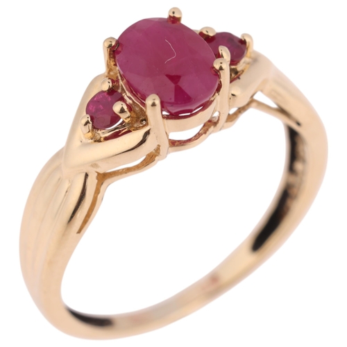 1368 - A 9ct gold three stone ruby dress ring, London 2003, set with oval and round-cut rubies, setting hei... 