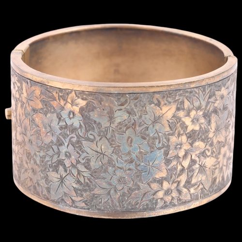 1454 - A Victorian silver-gilt hinged bangle, maker J&THF, Birmingham 1883, engraved floral decoration, ban... 