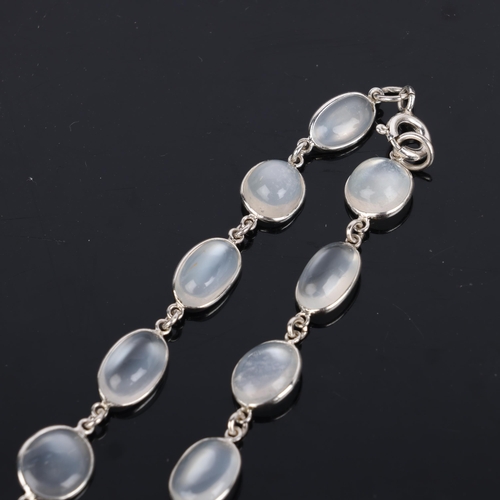 1542 - A single-strand sterling silver graduated moonstone tennis line necklace, set with oval cabochon moo... 