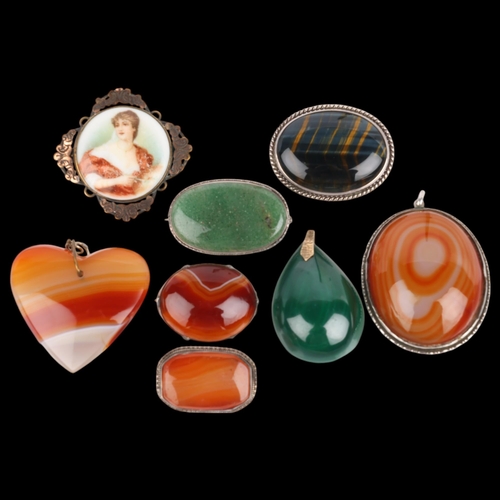 1553 - A quantity of hardstone brooches and pendants, including hawks eye, malachite, banded agate, etc