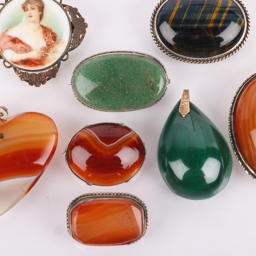 1553 - A quantity of hardstone brooches and pendants, including hawks eye, malachite, banded agate, etc