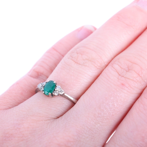 1394 - An 18ct white gold emerald and diamond ring, maker SFJ, London 2013, claw set with oval mixed-cut em... 