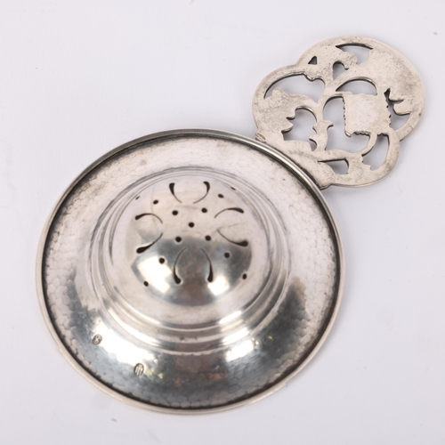 1612 - An Art Deco Danish silver tea strainer, circa 1933, openwork floral handle with planished and pierce... 