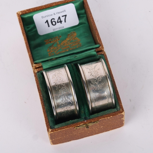 1647 - A cased pair of George V silver napkin rings, Joseph Gloster Ltd, Birmingham 1920, floral engraved d... 