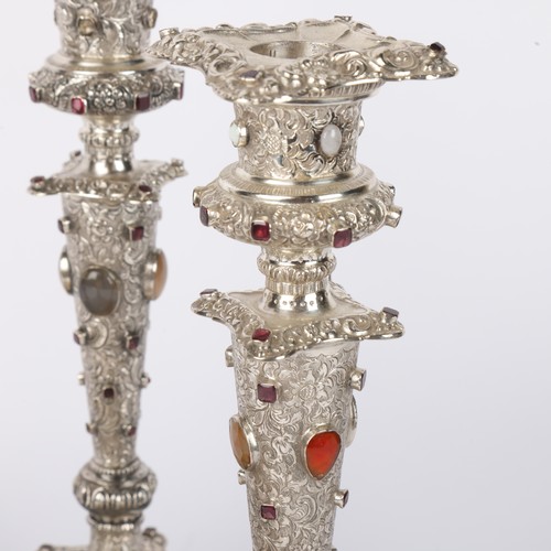 1653 - A set of 4 Austrian gem set silver table candlesticks, Vienna circa 1859, allover relief embossed fo... 