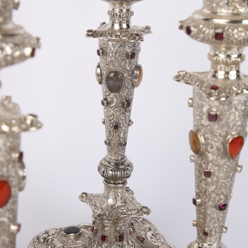 1653 - A set of 4 Austrian gem set silver table candlesticks, Vienna circa 1859, allover relief embossed fo... 