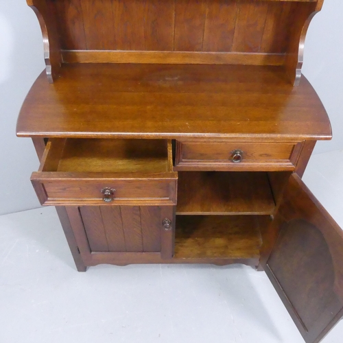 2125 - A reproduction oak two-section dresser, with open plate rack, two drawers and arch panelled cupboard... 