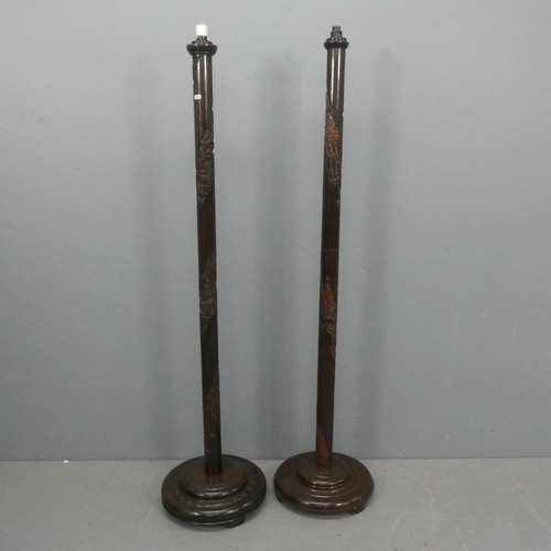 2242 - Two similar oriental carved oak standard lamps. Height to bayonet 161cm.