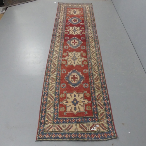 2283 - A cream and red-ground Caucasian runner. Length 310cm, width 81cm.