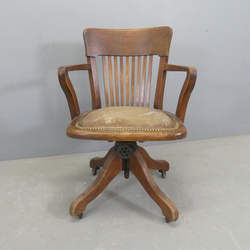 2515 - An early 20th century oak and upholstered swivel desk chair.