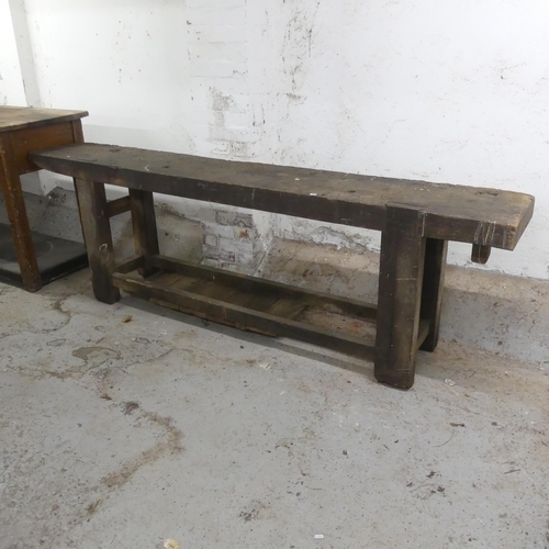 2563 - An antique stained pine two-tier work bench. Width 242cm, height 76cm, depth 40cm.