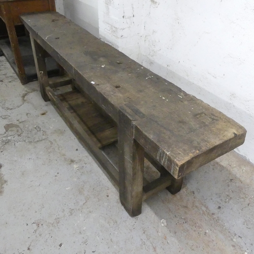 2563 - An antique stained pine two-tier work bench. Width 242cm, height 76cm, depth 40cm.