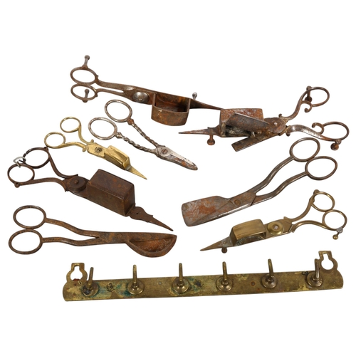 132 - A collection of various brass and steel candle snuffers, brass key rack