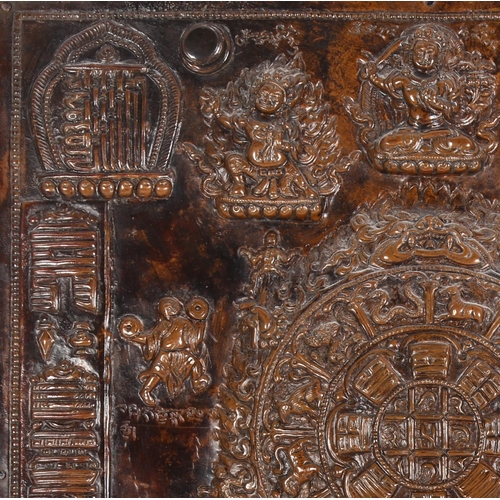 195 - A 19th century Tibetan Thangka, a repousse decorated copper panel depicting Buddhas with script, pan... 