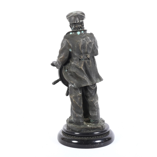 3 - A bronze mantel clock in the form of a helmsman holding, the ship's wheel holding the clock with pai... 