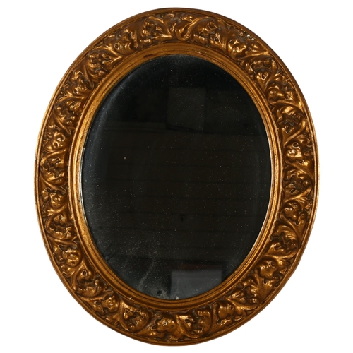 302 - An ornate composite oval wall mirror, 65cm x 56cm