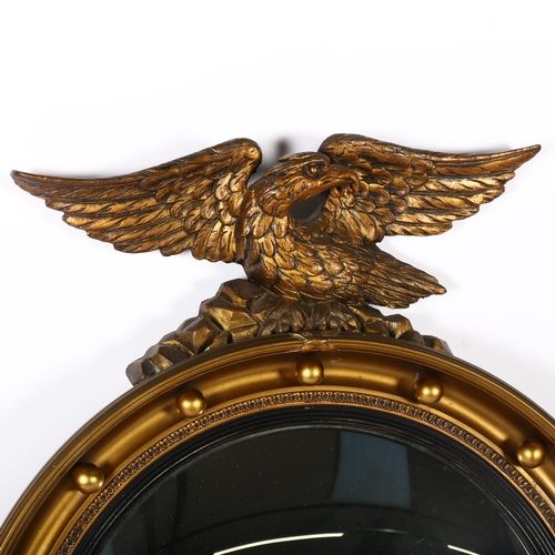 306 - A giltwood and plaster convex wall mirror with Federal style eagle mount, overall 69cm x 53cm