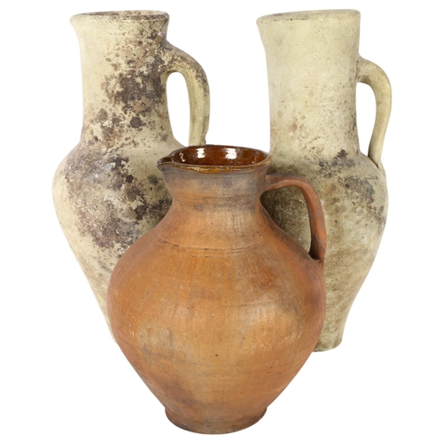 361 - A pair of single-handled pottery ewers, and a terracotta jug