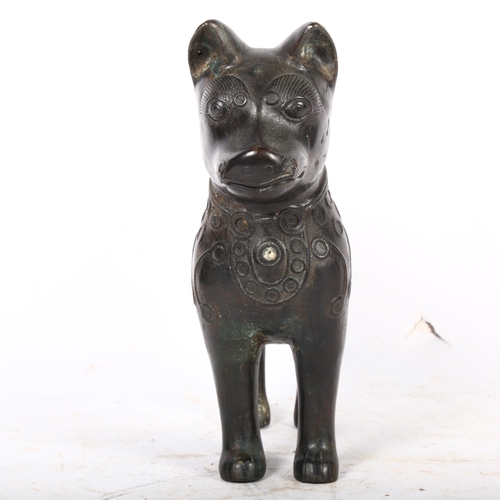 424 - An Oriental patinated bronze figure of a dog with a curly tail, with embossed decoration, H25.5cm