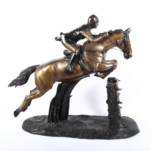 5 - A large bronze group depicting a racing horse and jockey over the jumps, on a textured base, H56cm