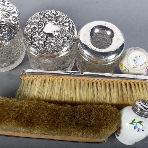 565 - 2 silver-backed dressing table brushes, 2 glass-top hair tidies, a silver-topped toilet jar, and a p... 