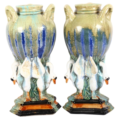 641 - A large pair of stoneware drip glazed vases, supported by 3 swans, on triangular plinth, H42cm