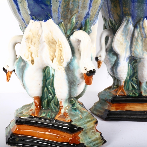 641 - A large pair of stoneware drip glazed vases, supported by 3 swans, on triangular plinth, H42cm