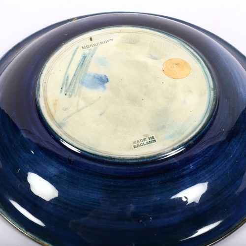 693 - A Moorcroft Pomegranate design dish, with dark blue and green ground background, signed and stamped ... 