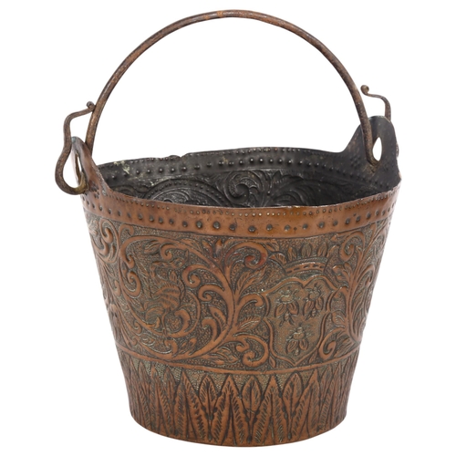 751 - An ornate Antique copper bucket with detailed allover repousse hammered decoration, including to bas... 