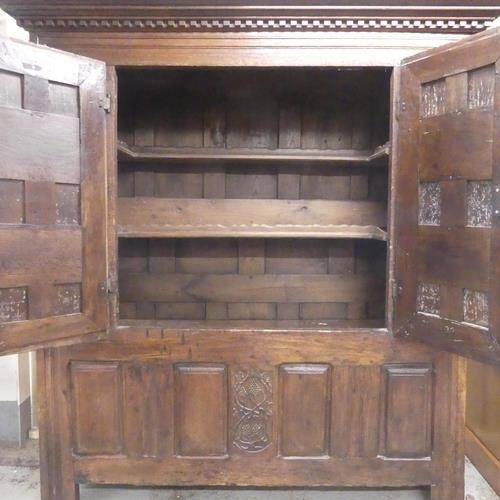 2508 - A 17th century and later panelled oak larder cupboard, with two doors revealing a shelf fitted inter... 