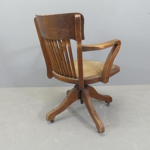 2515 - An early 20th century oak and upholstered swivel desk chair.