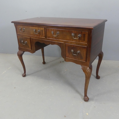 2528 - A reproduction mahogany and satinwood strung kneehole writing desk, with four drawers and raised on ... 