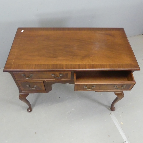 2528 - A reproduction mahogany and satinwood strung kneehole writing desk, with four drawers and raised on ... 