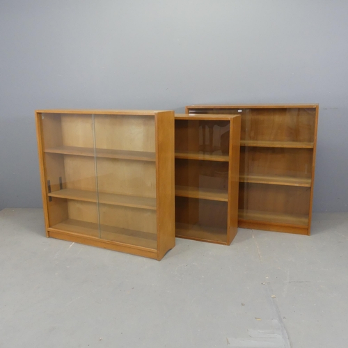 2551 - Three mid-century teak bookcases with glass sliding doors, all labelled for Phonix Gallery, London, ... 