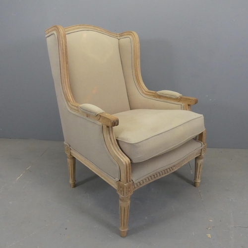 2557 - A continental style oak and upholstered wingback armchair.