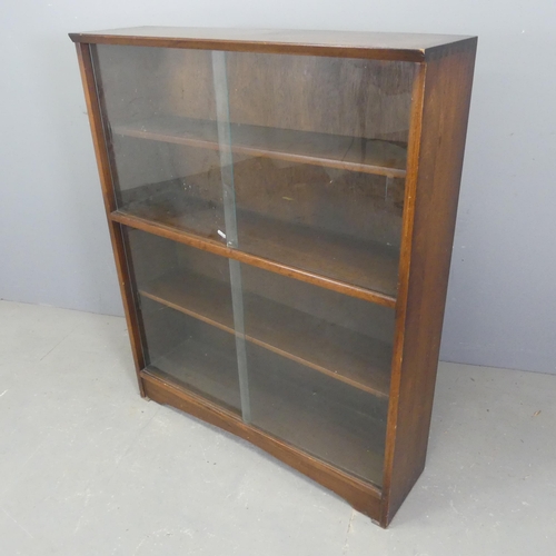 2558 - A mid-century teak bookcase with glass sliding doors, with label for Herbert E. Gibbs</b<. Width 92c... 