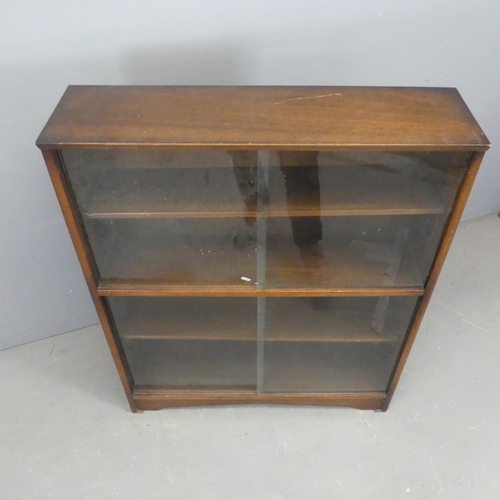 2558 - A mid-century teak bookcase with glass sliding doors, with label for Herbert E. Gibbs</b<. Width 92c... 