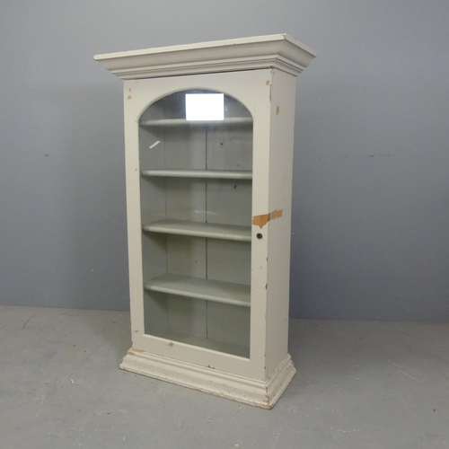 2580 - A painted pine bookcase with single glazed door. Width 73cm, height 121cm, depth 32cm.