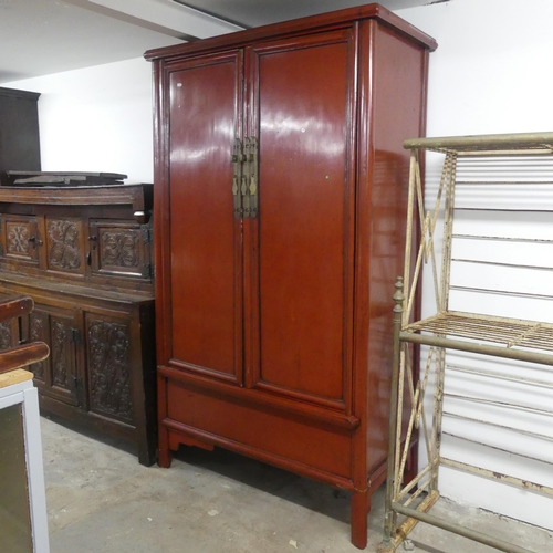 2589 - A Chinese red-lacquered two door cabinet. Width 108cm, height 185cm, depth 52cm.