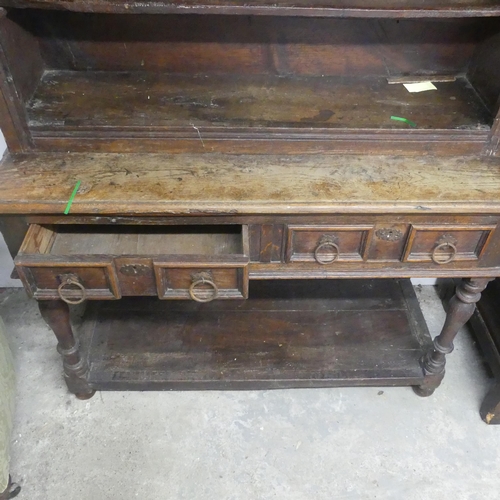 2591 - A 19th century two-section oak dresser, the upper section shelved, the lower with two drawers and po... 