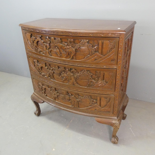 2692 - A Chinese hardwood bow-front chest of three long drawers, with all-over carved decoration and raised... 