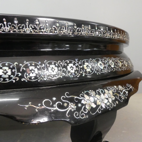 2693 - A modern Korean black lacquered oval low coffee table, with inlaid mother-of pearl phoenix decoratio... 