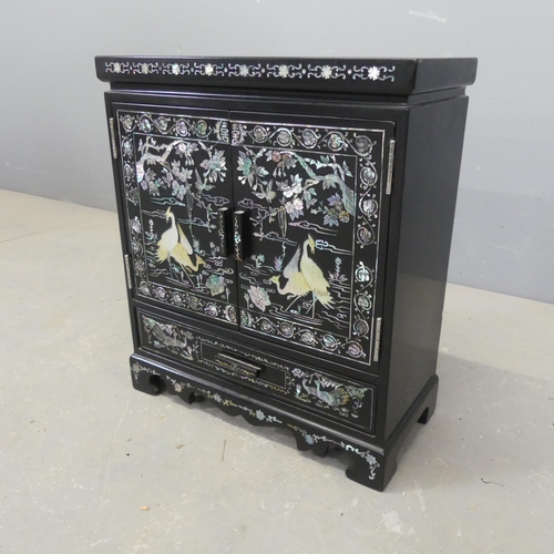 2697 - A Korean black lacquered jewellery cabinet, with two doors revealing a drawer fitted interior, a sin... 