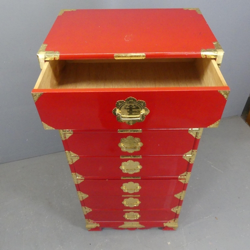 2702 - A Korean red-lacquered kiriwood Tansu chest of seven drawers, with brass mounts and pulls. Width 61c... 