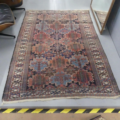 2306 - A red and blue-ground Persian rug. Length 200cm, width 140cm.