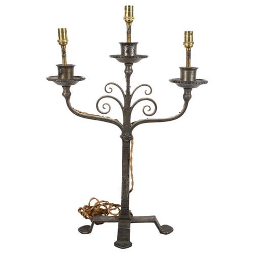 810 - An early 20th century Cotswold School iron candelabrum, adapted for electricity, H46cm